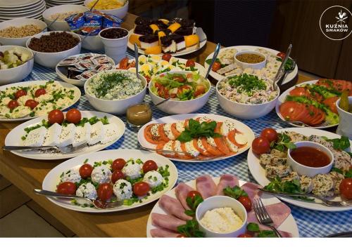 a table with many plates of food on it at Hotel Kuźnia Smaków in Małe Pułkowo