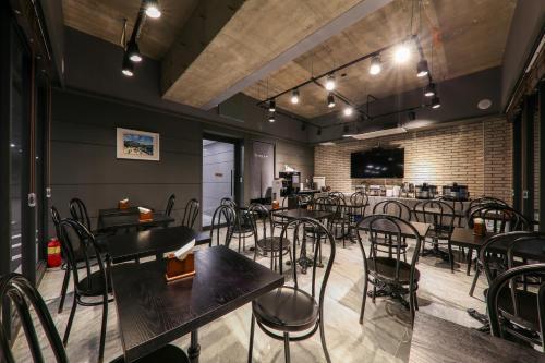a restaurant with tables and chairs and a bar at Bcent hotel in Busan