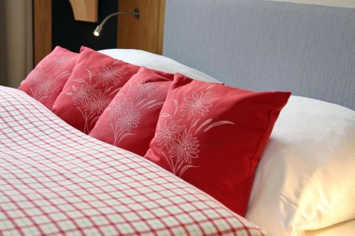 a pile of pillows on top of a bed at Lebensart am See in Bad Endorf