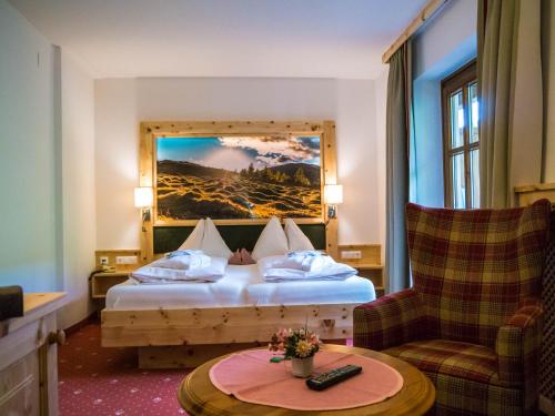 a hotel room with a bed and a chair at Hotel Gasthof Hinteregger in Bad Kleinkirchheim