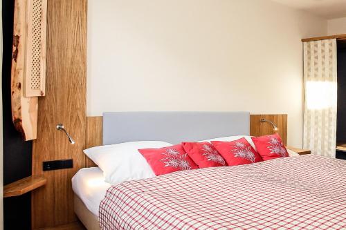 a bedroom with a bed with red and white sheets at Lebensart am See in Bad Endorf