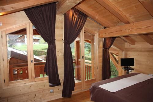 een slaapkamer met een groot raam in een blokhut bij L Aube Claire in Morzine