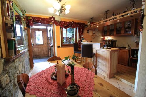 a kitchen with a table with a red table cloth at Baita Zeni Tirolerhof in Fiera di Primiero