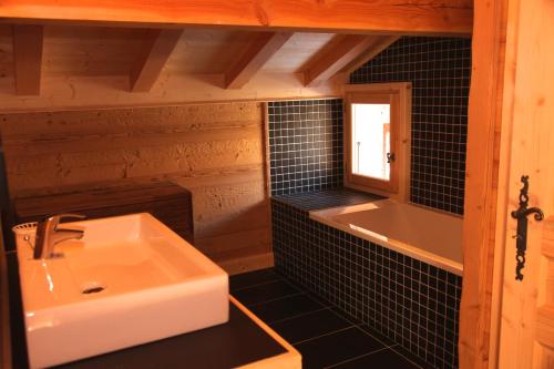een badkamer met een wastafel en een ligbad bij L Aube Claire in Morzine