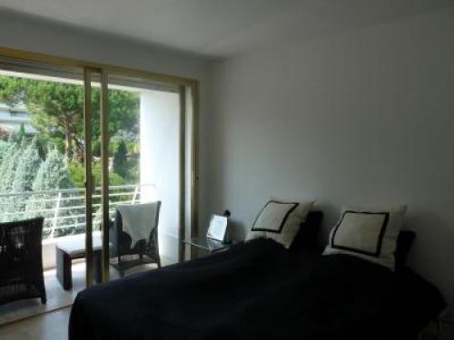 une chambre avec un lit et deux chaises et une fenêtre dans l'établissement Two Bed apartment in a gated residence with gardens in Cannes with sea views 865, à Cannes