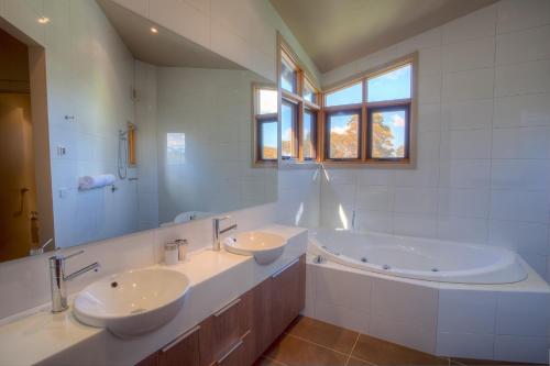 łazienka z 2 umywalkami i dużym lustrem w obiekcie Majella w mieście Dinner Plain