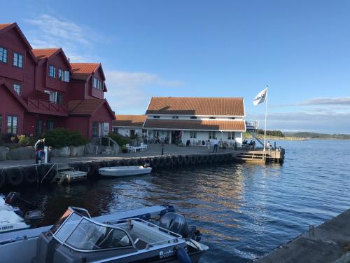 a boat docked at a dock next to a building at Sjøberg Hotell og Ferie Leiligheter in Østhusvik