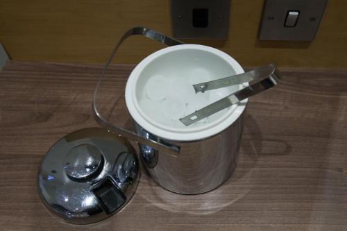 a metal trash can with two tongs in it at Best Western Victoria Palace in London