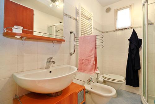 a bathroom with a white sink and a toilet at Casa Alberto in Lucca