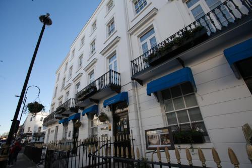 a white building with balconies on a street at Best Western Victoria Palace in London