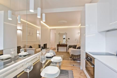 uma cozinha e sala de estar com mesa e cadeiras em BmyGuest - Exclusive Downtown Apartment em Lisboa