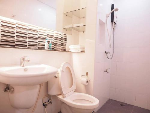 une salle de bains blanche avec toilettes et lavabo dans l'établissement Baan mek mok, à Bangkok