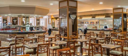 a restaurant with tables and chairs and a bar at Relaxia Beverly Park in Playa del Ingles