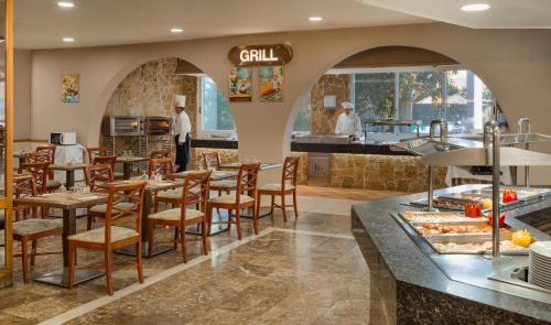 a restaurant with tables and chairs and a counter at Relaxia Beverly Park in Playa del Ingles