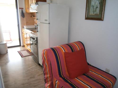 a kitchen with a white refrigerator and a couch at Antonios Rooms in Akrata