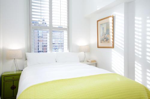 a bedroom with a large bed and a window at Retro apartment moments from Battersea Park in London