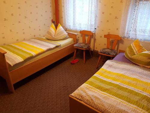 a small bedroom with two beds and two chairs at Monteurzimmer Talstrasse 2 in Nossen