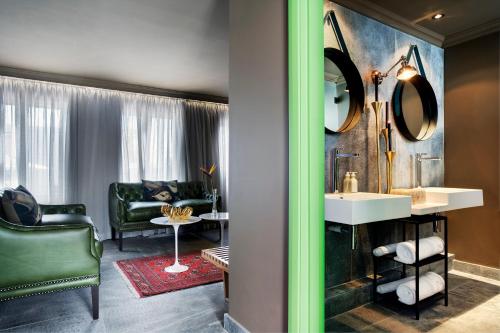a bathroom with a sink and a living room at Majeka House Boutique Hotel by The Living Journey Collection in Stellenbosch