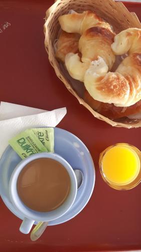 a table with a cup of coffee and a basket of bread at Hotel Azul Marino in Santa Teresita