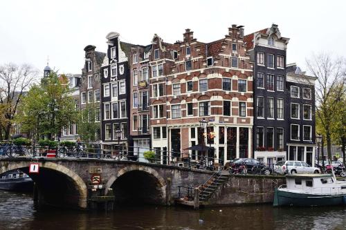 a bridge over a river in front of buildings at Holiday home Landelijk Amsterdam in Amsterdam