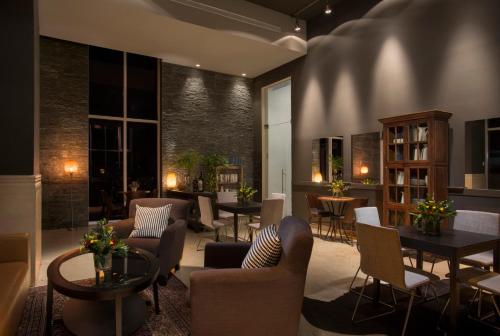 a living room with couches and tables and chairs at Island Luxurious Suites Hotel and Spa in Netanya