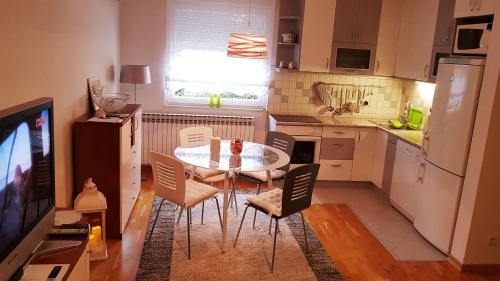 a small kitchen with a table and chairs and a television at Apartment Dominik in Osijek
