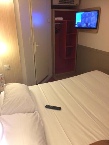 a remote control on a bed in a hotel room at Premiere Classe Tours Sud - Chambray Lès Tours in Chambray-lès-Tours