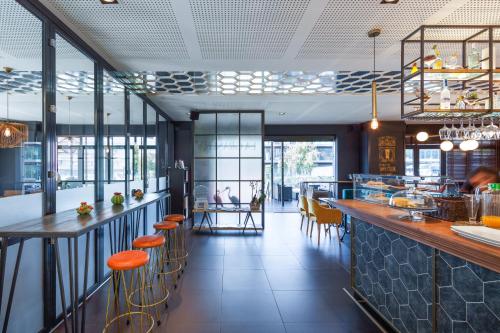 a restaurant with a bar with orange stools at Ibis Styles A Coruna in A Coruña