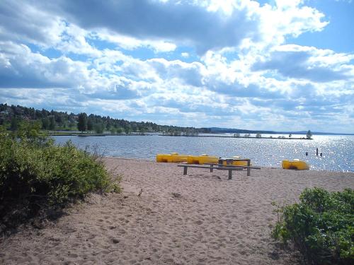 a picnic table on a beach next to the water at Relax House Rättvik Spa Nordic in Rättvik