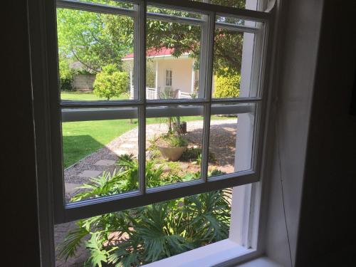 an open window with a view of a yard at Oude Berg Guesthouse - 10 Caledon Street in George