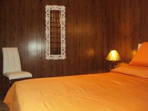 カリアリにあるB&B antica cittàのベッドルーム1室(ベッド1台、椅子、鏡付)