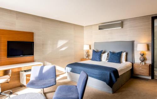 a hotel room with a bed and a flat screen tv at Lions Eye Luxury Apartments in Cape Town