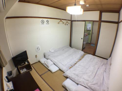 a small room with two beds and a television at Kenroku Haitsu 301 in Kanazawa