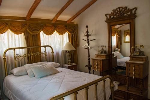 a bedroom with a bed and a large mirror at Hotel Museo Casona Ugarte Leon in Concepción