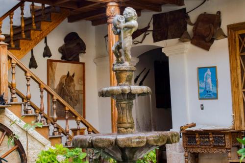 a stone fountain in theoyer of a house with stairs at Hotel Museo Casona Ugarte Leon in Concepción