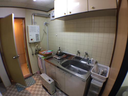 a kitchen with a sink and a tiled wall at Kenroku Haitsu 302 in Kanazawa