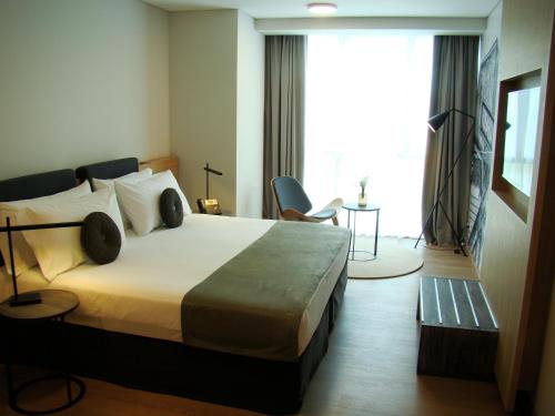 a hotel room with a bed and a large window at Dazzler by Wyndham Rosario in Rosario
