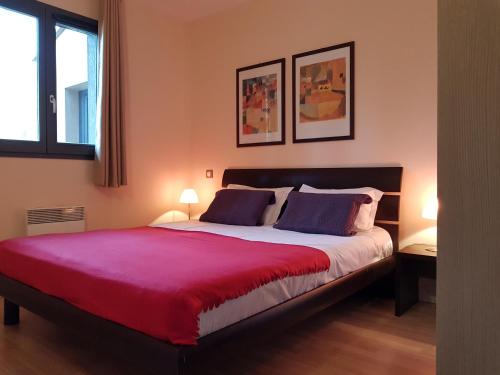 a bedroom with a large bed with a red blanket at Mas de Valrugues Holifrance in Saint-Rémy-de-Provence