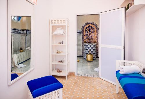 Riad Bab Agnaou & Spa في مراكش: غرفة ملابس مع مرآة وكرسي أزرق