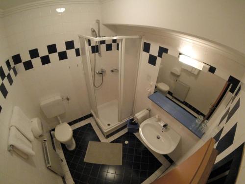 a small bathroom with a toilet and a sink at CenterCourt Hotel in Graz