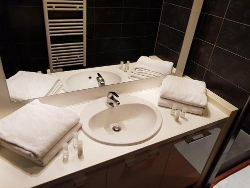 a bathroom with a white sink and a mirror at Mas de Valrugues Holifrance in Saint-Rémy-de-Provence