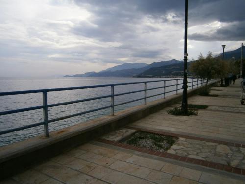 a sidewalk next to a body of water with a pole at Antonios Rooms in Akrata