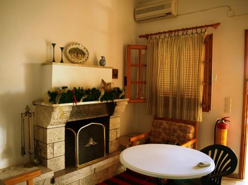 a living room with a fireplace and a table at Studio Candia in Kandia