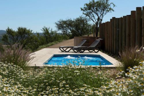 a swimming pool with two chairs in a garden at Villas Toscanas in Limache