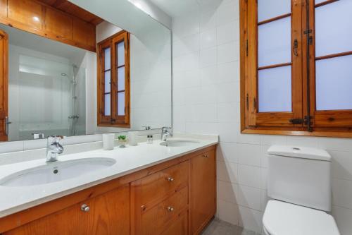ein Badezimmer mit einem Waschbecken, einem WC und einem Spiegel in der Unterkunft Flateli Aribau in Barcelona