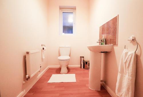 La salle de bains est pourvue de toilettes et d'un lavabo. dans l'établissement Royal Oak Home, à Wythenshawe