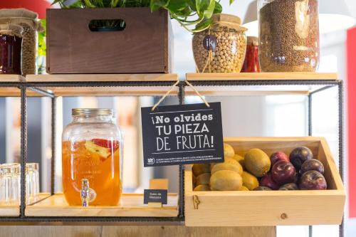 a shelf with a box of fruit and a sign at Ibis Barcelona Castelldefels in Castelldefels