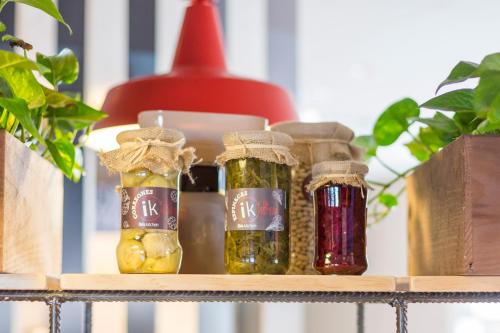 a shelf with four bottles of pickles on it at Ibis Barcelona Castelldefels in Castelldefels