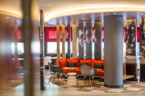 a restaurant with orange chairs and a table at Ibis Barcelona Castelldefels in Castelldefels