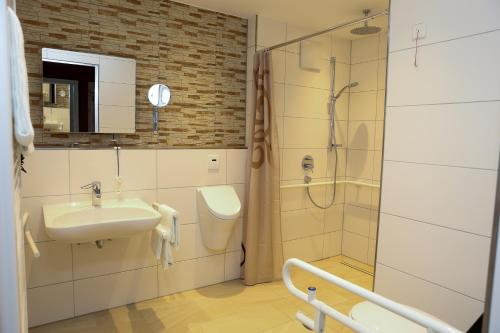 ein Bad mit einem Waschbecken und einer Dusche in der Unterkunft Germania Beck in Hülben